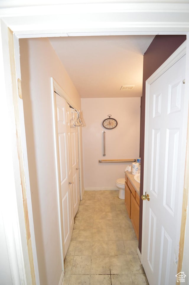 bathroom with toilet, vanity, and baseboards