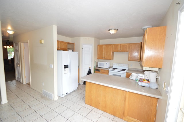 kitchen featuring white appliances, a peninsula, light tile patterned floors, and light countertops