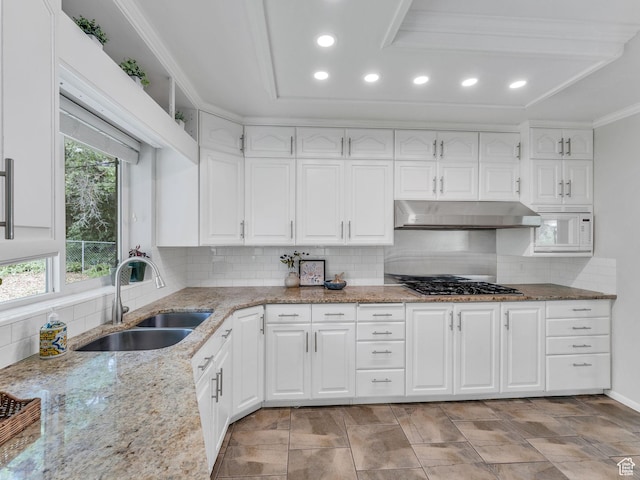 4131 S Fortuna Way E, Salt Lake City, UT 84124 - kitchen featuring a sink, under cabinet range hood, stainless steel gas cooktop, decorative backsplash, and white cabinetry