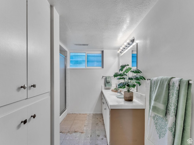 4131 S Fortuna Way E, Salt Lake City, UT 84124 - full bathroom with a stall shower, vanity, a textured ceiling, and baseboards