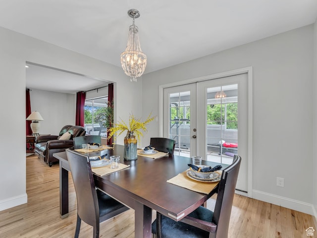 4131 S Fortuna Way E, Salt Lake City, UT 84124 - dining area with french doors, baseboards, a chandelier, and light wood-style flooring