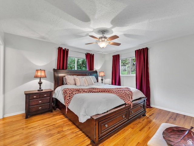 4131 S Fortuna Way E, Salt Lake City, UT 84124 - bedroom with multiple windows, light wood-style floors, baseboards, and a textured ceiling