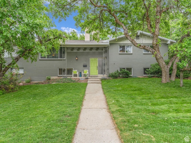4131 S Fortuna Way E, Salt Lake City, UT 84124 - split level home with a chimney, a front yard, and brick siding