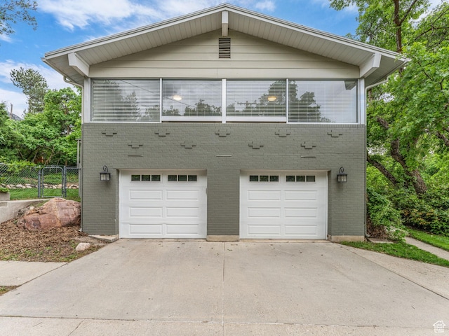 4131 S Fortuna Way E, Salt Lake City, UT 84124 - view of front facade featuring a garage, fence, concrete driveway, and brick siding