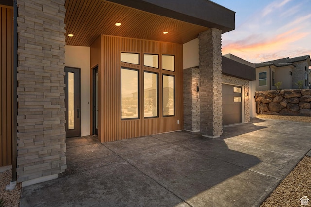 1575 W 840 S, Hurricane, UT 84737 - view of exterior entry with concrete driveway, a garage, stone siding, and stucco siding