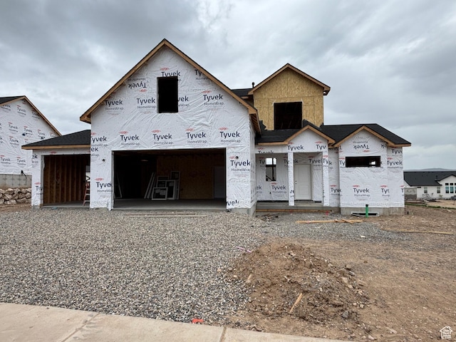 unfinished property with driveway and a garage