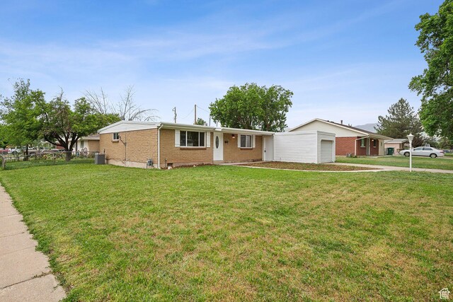 ranch-style house with brick siding, an attached garage, and central air condition unit