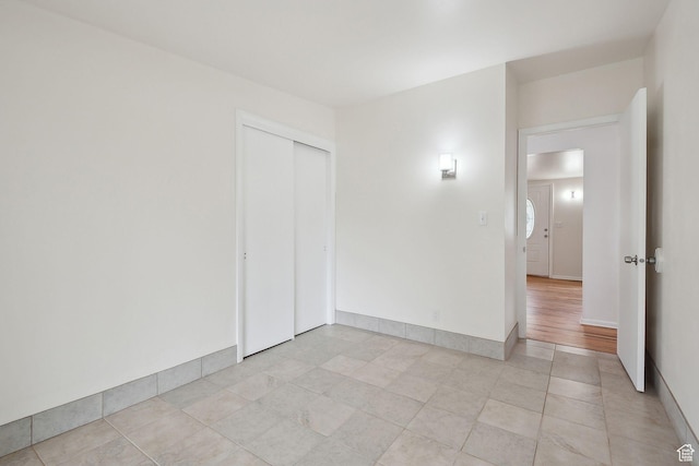 spare room featuring light tile patterned floors and baseboards