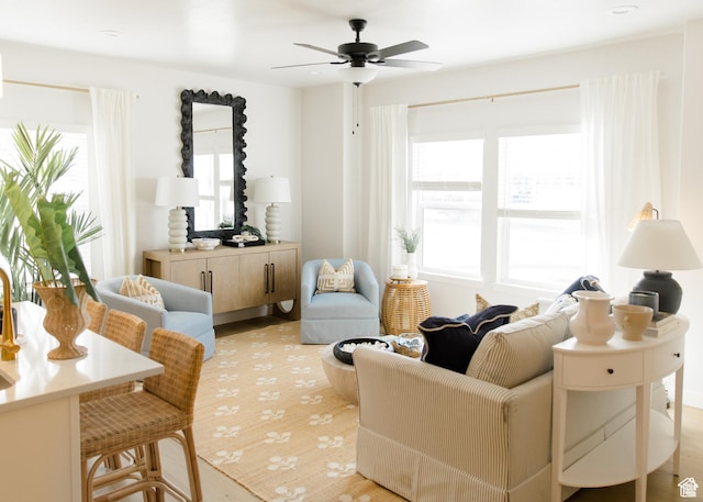 living area featuring healthy amount of natural light and ceiling fan