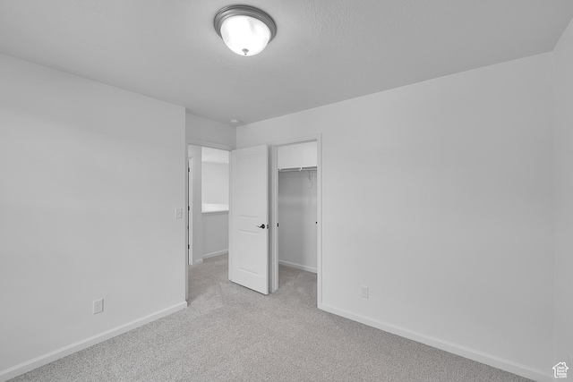 251 W 825 S Unit 306, Willard, UT 84340 - unfurnished bedroom featuring baseboards, light colored carpet, a walk in closet, and a closet