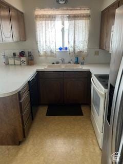 kitchen featuring white electric range, plenty of natural light, a sink, and light countertops
