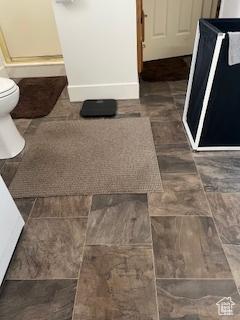bathroom featuring toilet and baseboards