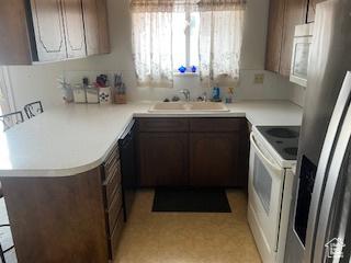 kitchen with electric range, stainless steel fridge with ice dispenser, a sink, and light countertops