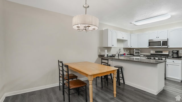 217 E 2300 N, North Ogden, UT 84414 - kitchen featuring stainless steel appliances, dark wood finished floors, white cabinetry, a peninsula, and baseboards