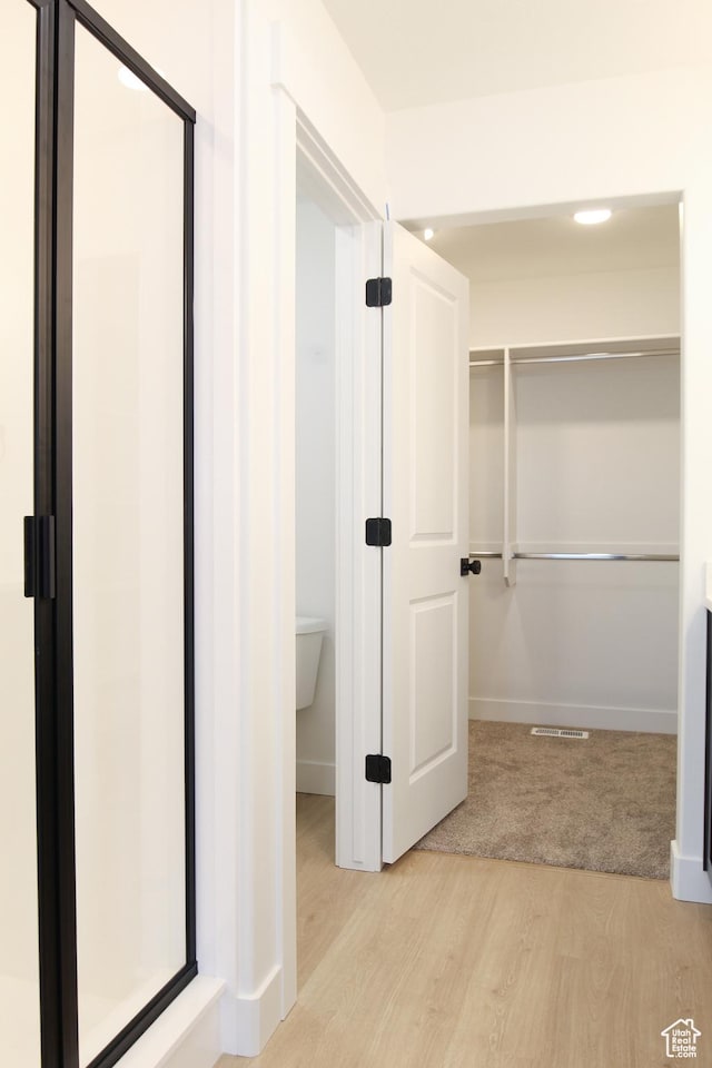 hall featuring light wood-type flooring and baseboards