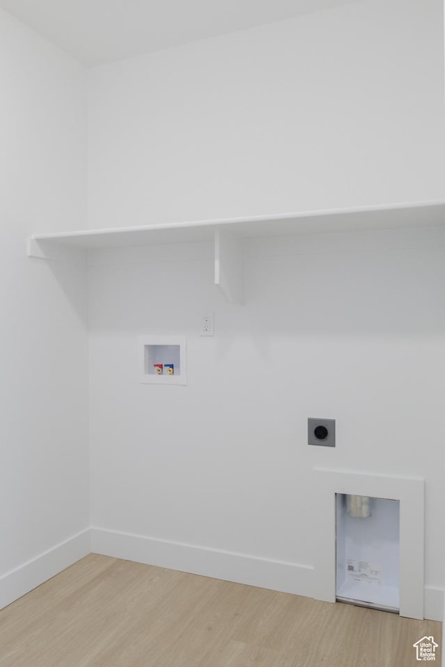 washroom featuring light wood-style floors, hookup for a washing machine, hookup for an electric dryer, and baseboards