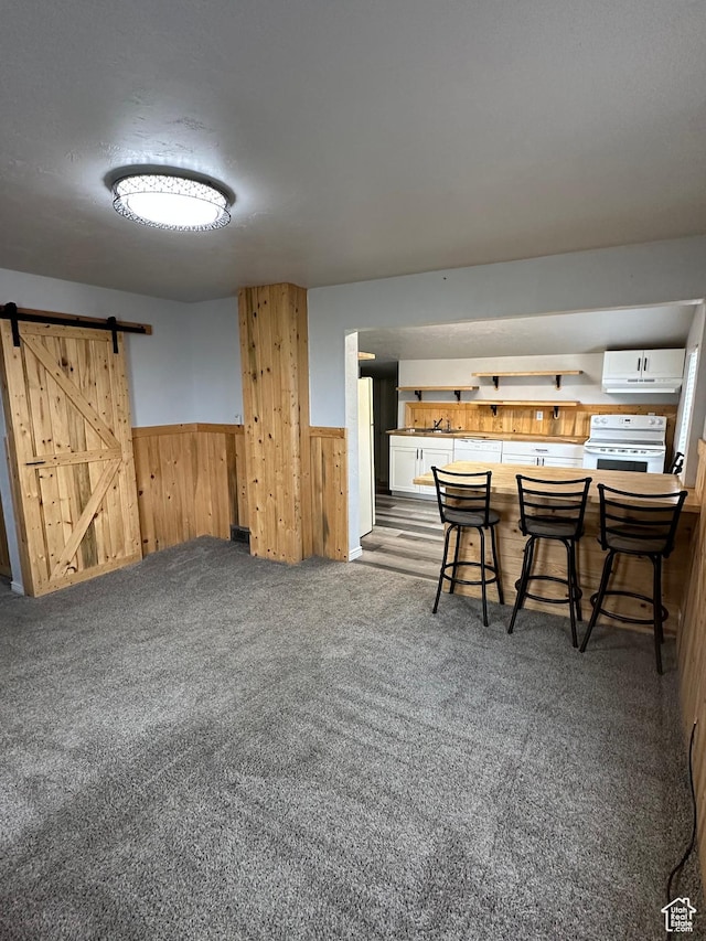 733 Clay St, Montpelier, ID 83254 - dining room featuring a barn door, wainscoting, wood walls, and carpet floors