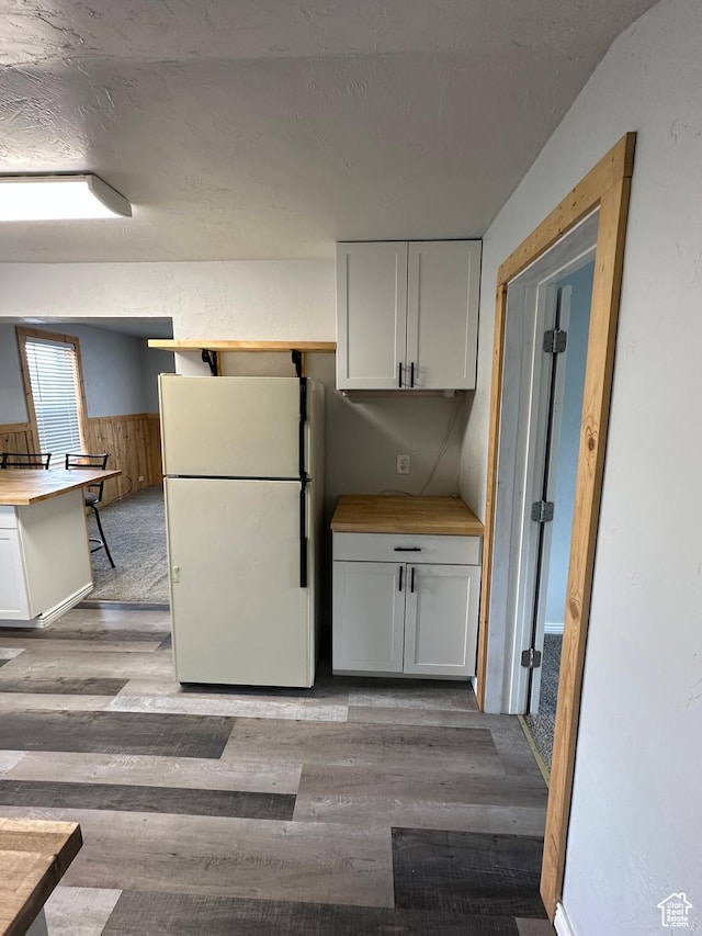 733 Clay St, Montpelier, ID 83254 - kitchen featuring freestanding refrigerator, wood finished floors, wainscoting, white cabinetry, and a textured ceiling