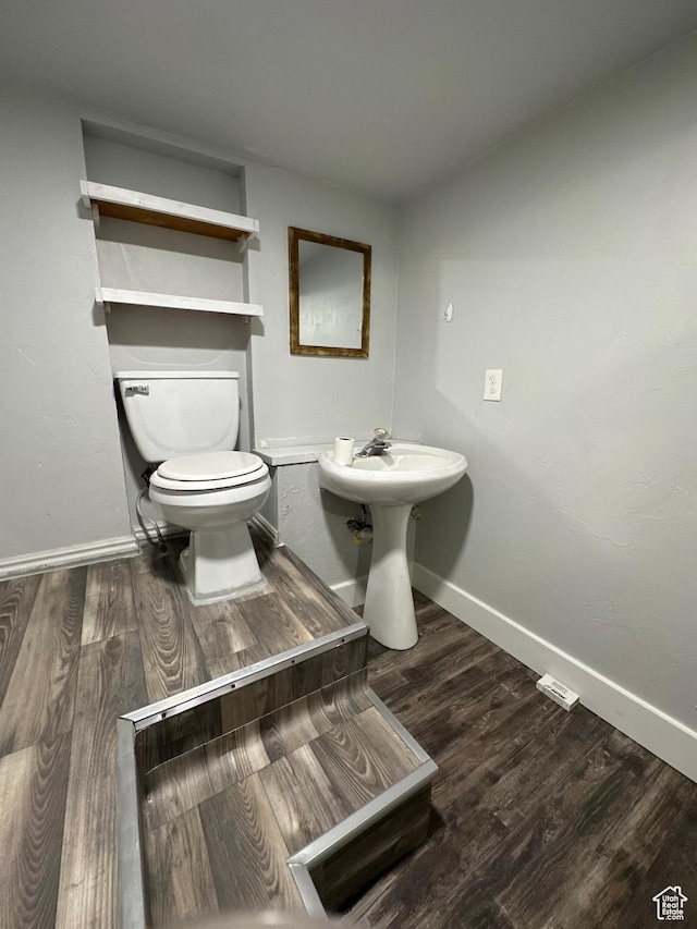 733 Clay St, Montpelier, ID 83254 - bathroom featuring baseboards, wood finished floors, toilet, and a sink