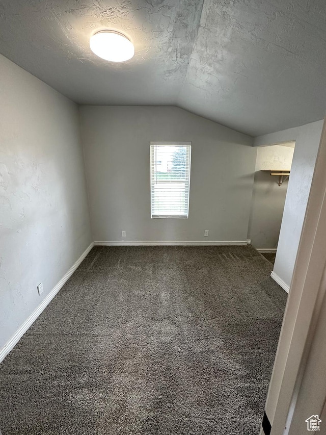 733 Clay St, Montpelier, ID 83254 - empty room featuring vaulted ceiling, a textured ceiling, dark colored carpet, and baseboards