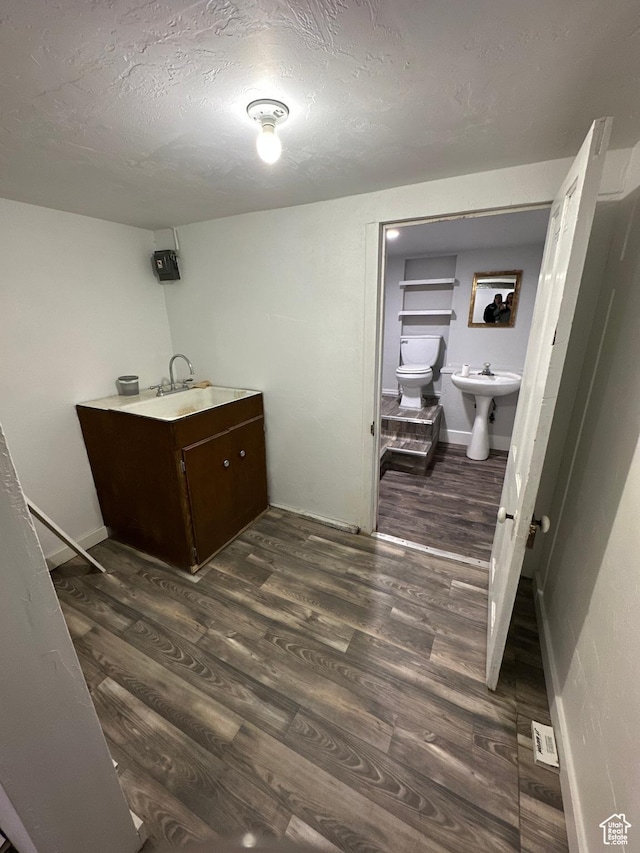 733 Clay St, Montpelier, ID 83254 - clothes washing area featuring a sink, dark wood-style flooring, baseboards, and a textured ceiling