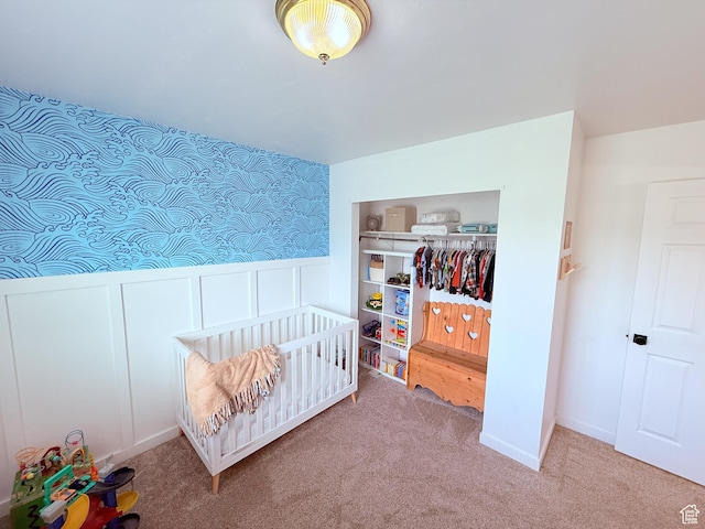 5582 W Joshua Cir S, West Jordan, UT 84081 - bedroom featuring a closet, carpet, a wainscoted wall, a nursery area, and a decorative wall