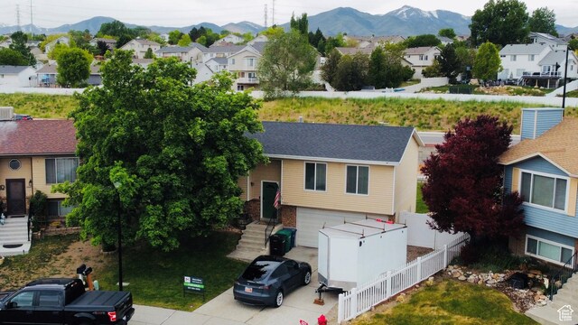 5582 W Joshua Cir S, West Jordan, UT 84081 - split foyer home with a residential view, a mountain view, a garage, fence, and a shingled roof