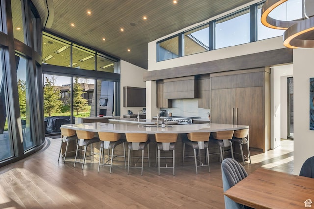 800 Hollyhock St, Park City, UT 84098 - kitchen with a high ceiling, light countertops, a large island with sink, light wood-style floors, and modern cabinets