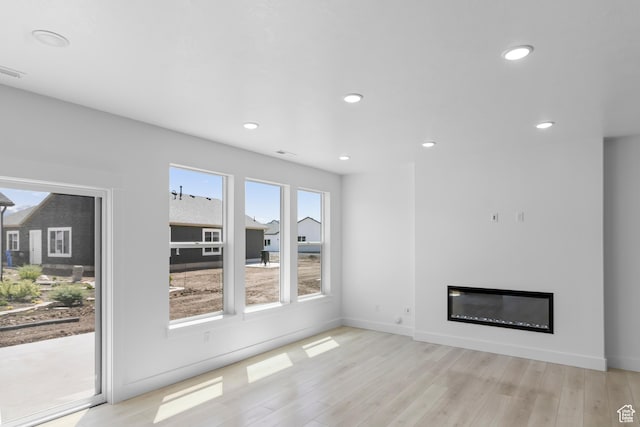 564 N 800 W, Smithfield, UT 84335 - unfurnished living room featuring light wood-type flooring, recessed lighting, a glass covered fireplace, and baseboards