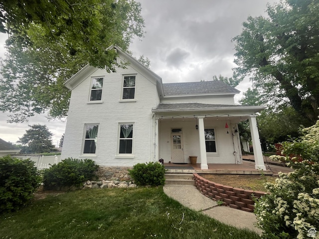 375 E 200 S, Centerville, UT 84014 - view of front of house featuring a porch, a shingled roof, brick siding, and a front yard