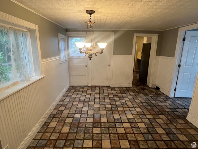 375 E 200 S, Centerville, UT 84014 - unfurnished dining area with a chandelier, a wainscoted wall, ornamental molding, and a textured ceiling
