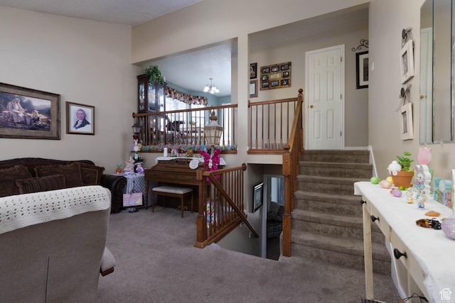 carpeted living area featuring a chandelier and stairway
