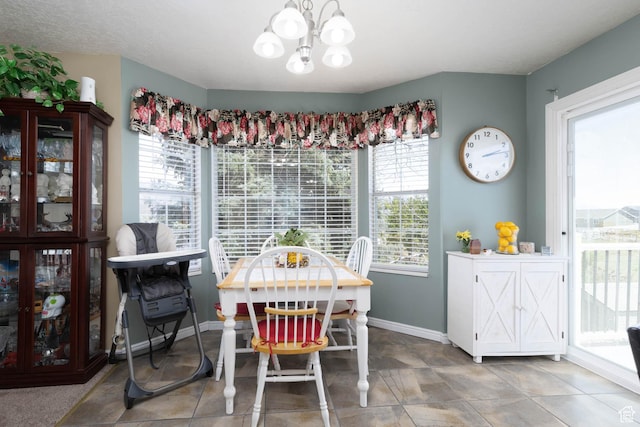 dining room with a chandelier and baseboards