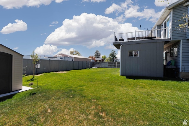 view of yard featuring a storage shed, an outbuilding, and a balcony