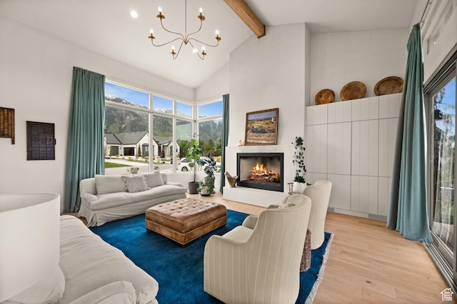 10076 S Wild Goose Cv E, Sandy, UT 84092 - living room with beam ceiling, wood finished floors, a chandelier, high vaulted ceiling, and a lit fireplace
