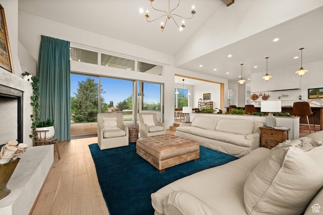 10076 S Wild Goose Cv E, Sandy, UT 84092 - living area with high vaulted ceiling, a chandelier, light wood-type flooring, recessed lighting, and a fireplace with raised hearth