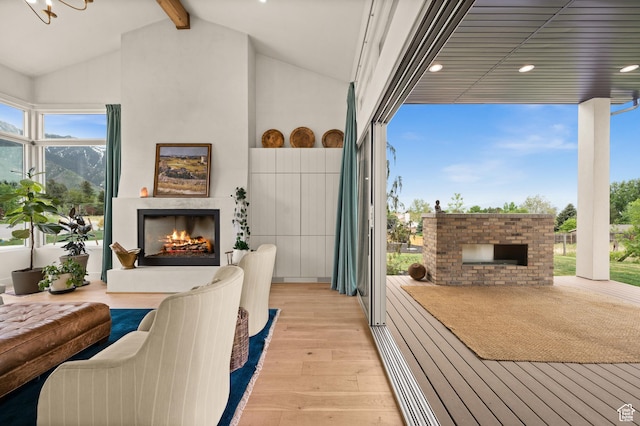 10076 S Wild Goose Cv E, Sandy, UT 84092 - living area with a warm lit fireplace, light wood-style floors, and recessed lighting