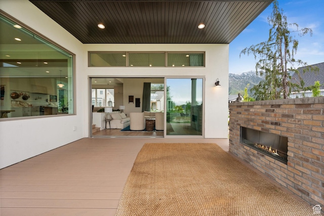 10076 S Wild Goose Cv E, Sandy, UT 84092 - view of patio with an outdoor brick fireplace and a mountain view