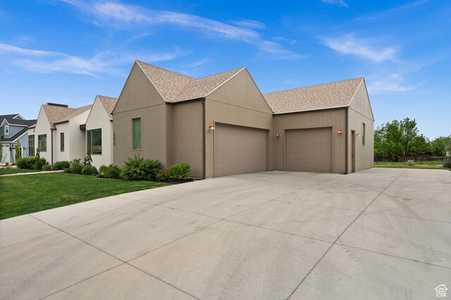 10076 S Wild Goose Cv E, Sandy, UT 84092 - view of front of property featuring an attached garage, a shingled roof, driveway, and a front lawn