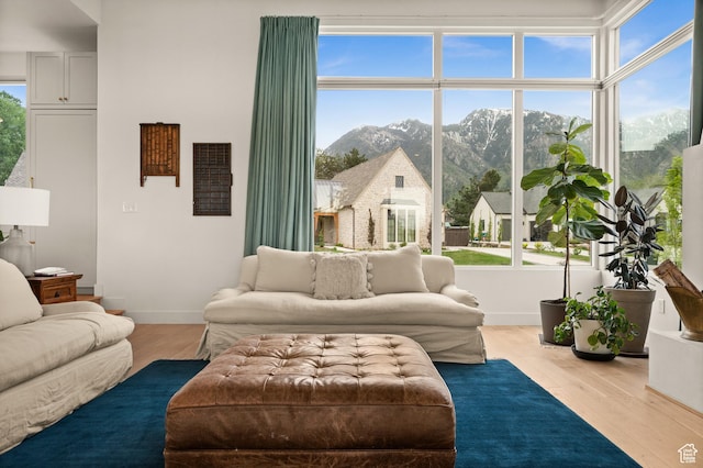 10076 S Wild Goose Cv E, Sandy, UT 84092 - living room featuring a mountain view, wood finished floors, and baseboards
