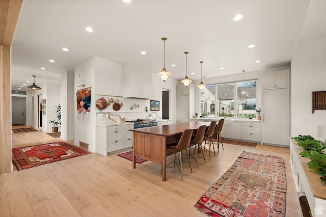 10076 S Wild Goose Cv E, Sandy, UT 84092 - kitchen featuring recessed lighting, light wood-style flooring, custom exhaust hood, and pendant lighting