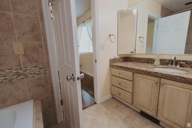 full bath featuring vanity, baseboards, and tile patterned floors