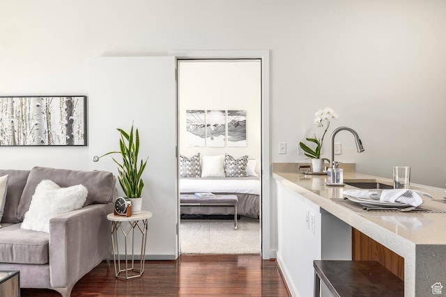 sitting room featuring dark wood-style flooring and baseboards
