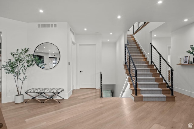 entryway with wood finished floors, recessed lighting, stairs, and baseboards