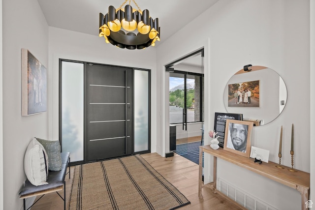 entrance foyer with wood finished floors and a chandelier