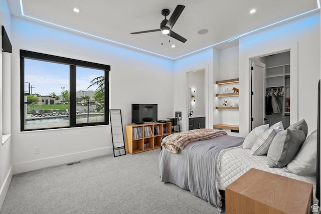 carpeted bedroom with a walk in closet, baseboards, connected bathroom, a closet, and recessed lighting