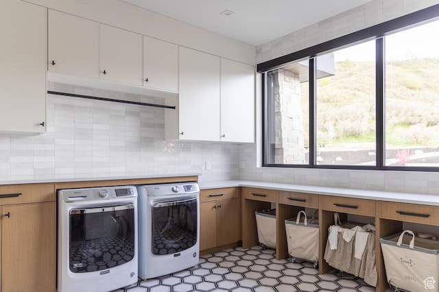 laundry area featuring cabinet space, independent washer and dryer, and healthy amount of natural light