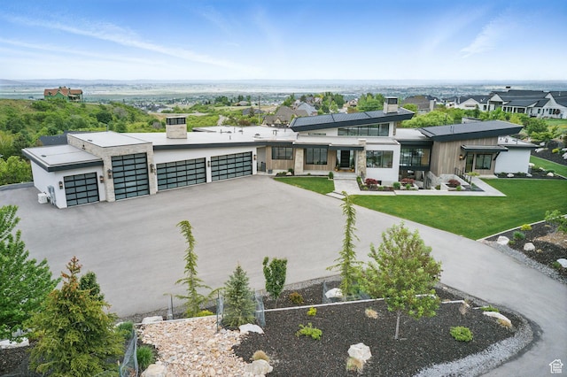 modern home with a chimney, a front lawn, and stucco siding