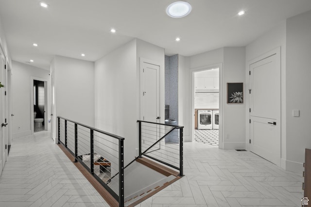corridor with an upstairs landing, baseboards, recessed lighting, and independent washer and dryer