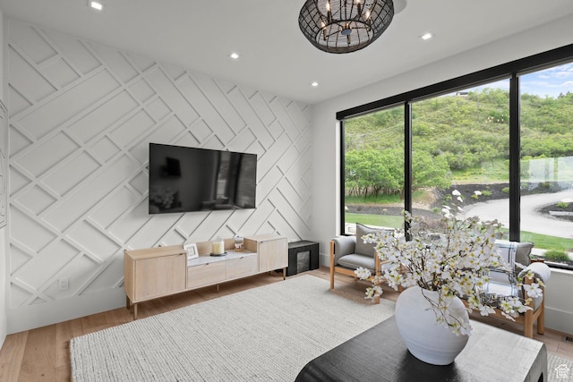 living room featuring wood finished floors, plenty of natural light, a decorative wall, an accent wall, and recessed lighting